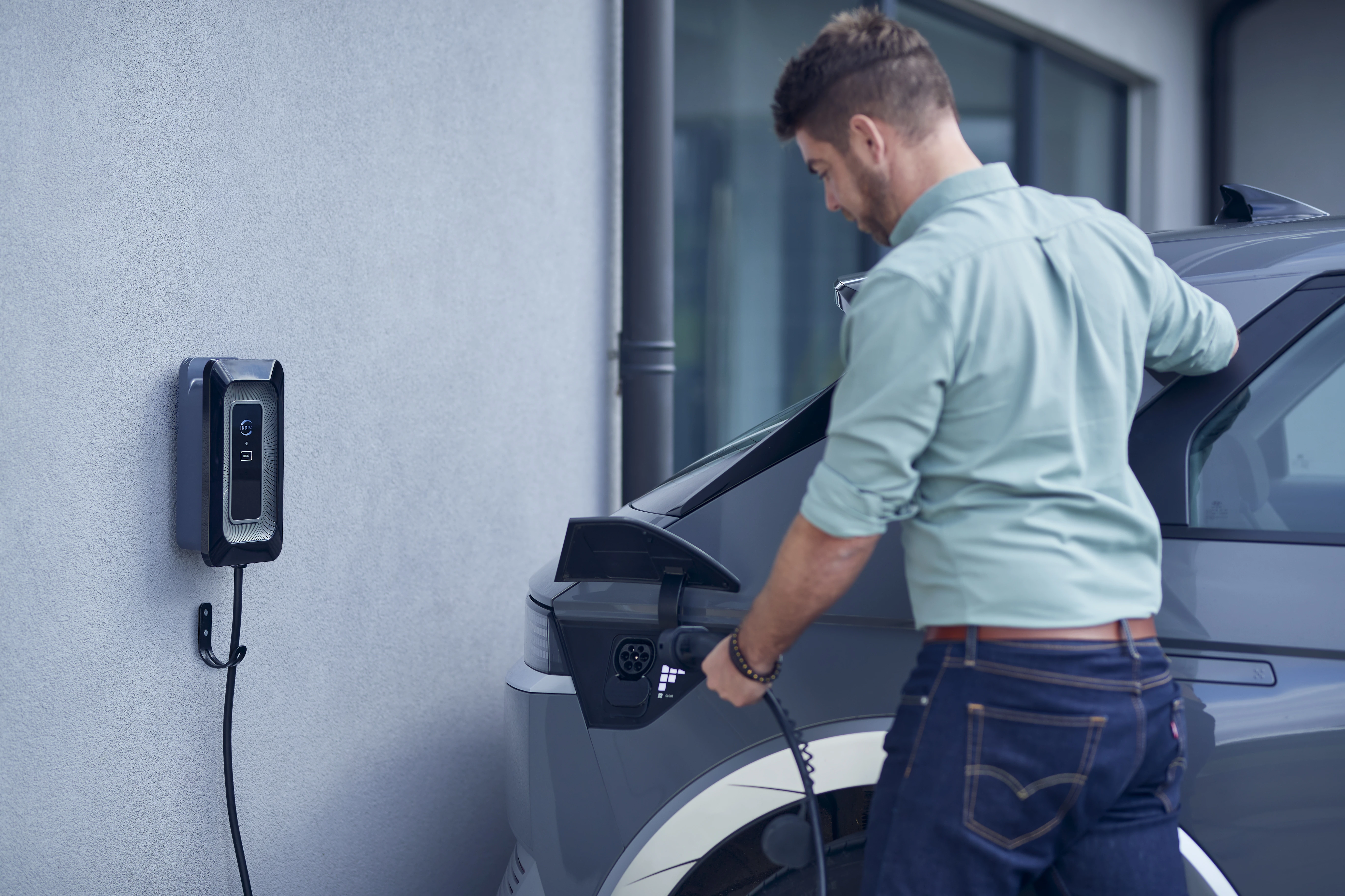 man charging his EV car at home