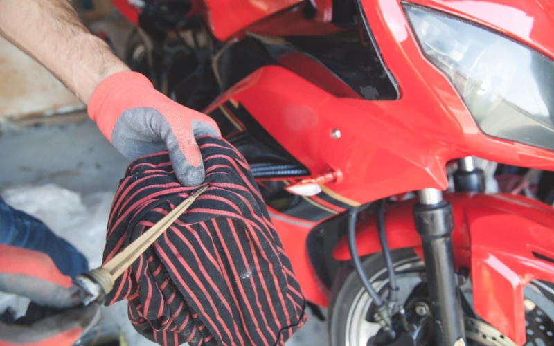 Checking motorcycle oil with dipstick.