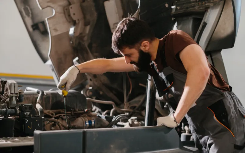 Mechanic checking the oil levels on a commercial truck.
