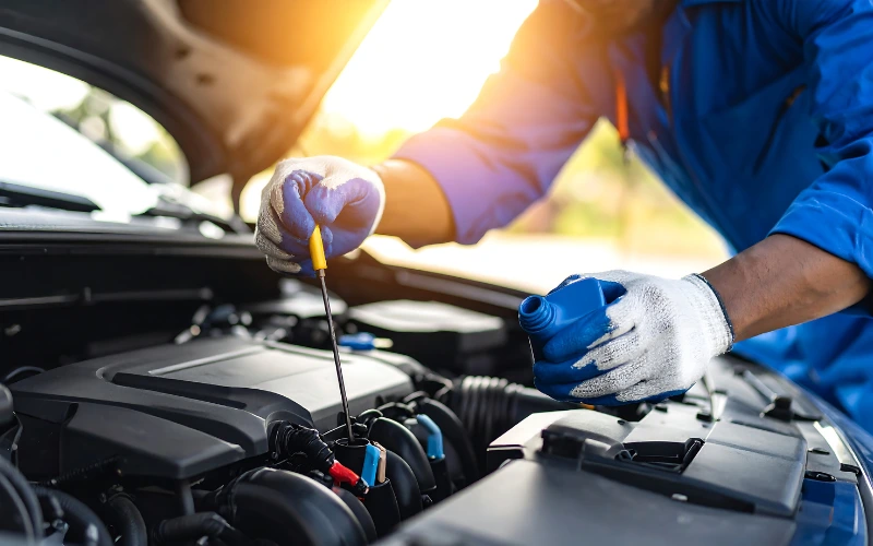 Mechanic checking engine oil levels.