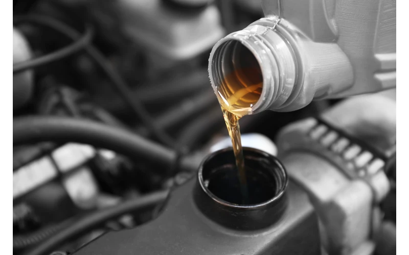 Close up of engine oil being poured from bottle.