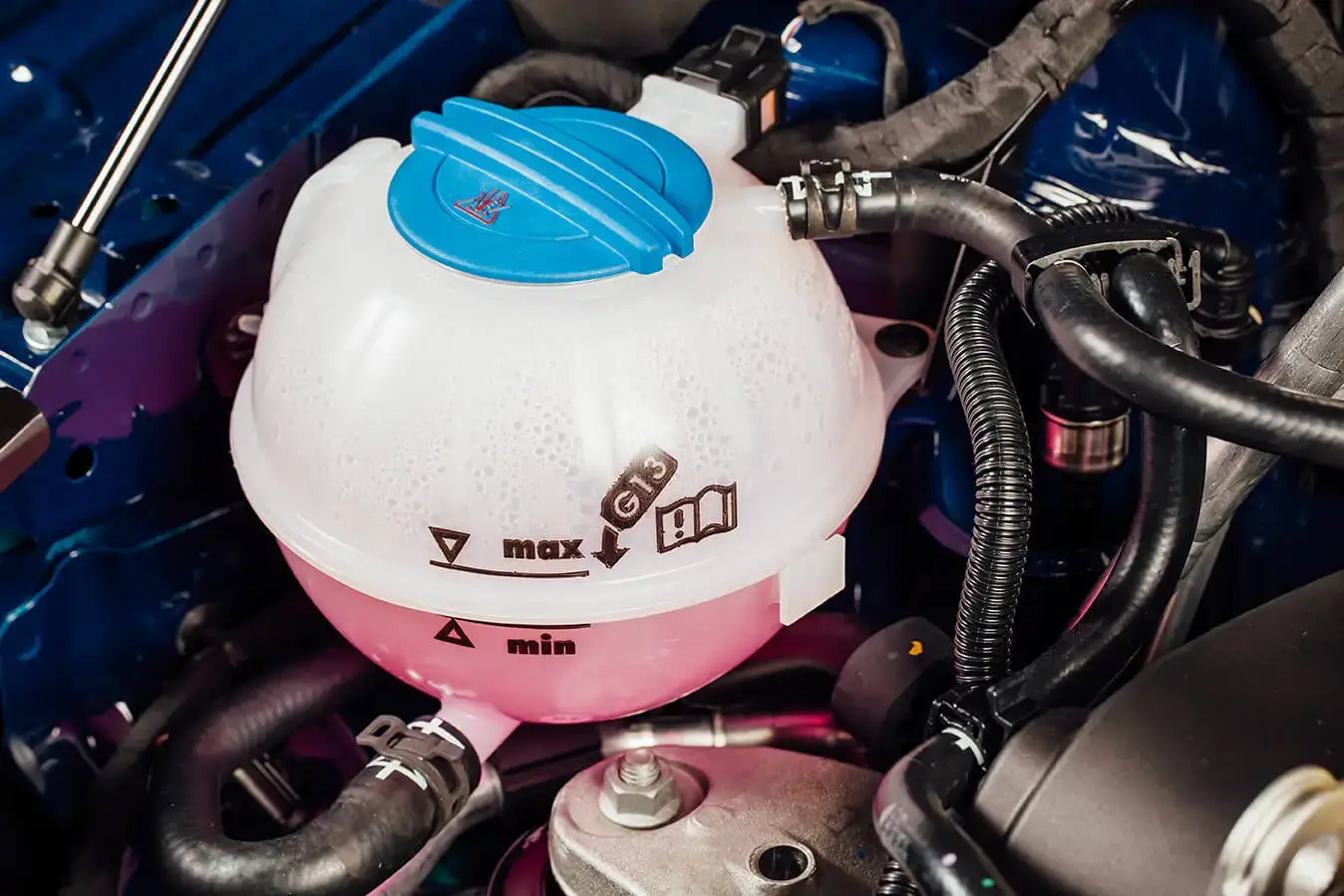 filling car radiator with 50/50 coolant mix, coolant reservoir and radiator cap refilling process
