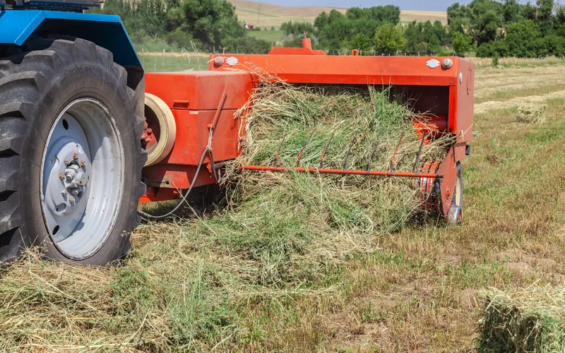 Close up of baler collecting crops in a field.