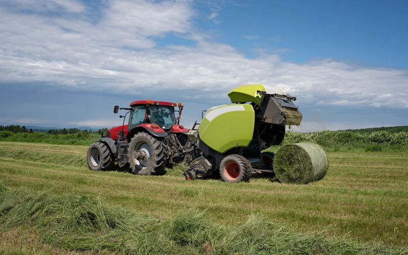 Wide image of baler working in a field.