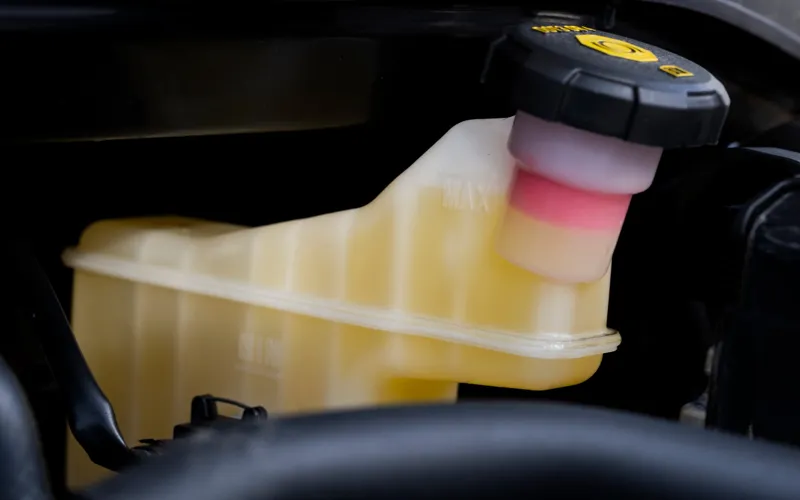 Close-up of yellow brake fluid in reservoir.