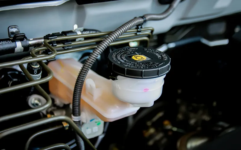 Close-up of brake fluid reservoir with labelled cap.