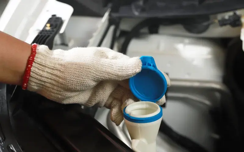 washer-fluid-cap-gloved-hand-