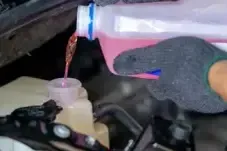 Thumbnail image adding antifreeze to car