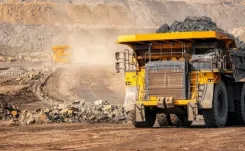  Large yellow quarry dump truck driving through dusty quarry thumbnail